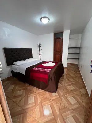 a bedroom with a bed and a wooden floor at Redys House in Cusco