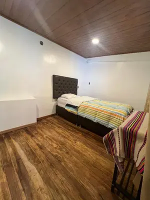 a bedroom with a bed and a chair in it at Redys House in Cusco