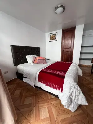 a bedroom with a large bed with a red blanket at Redys House in Cusco
