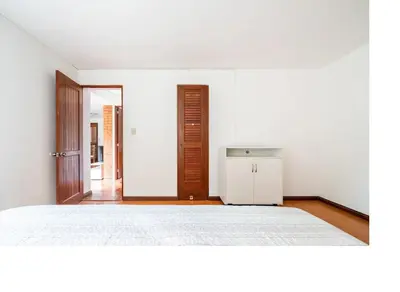 a white room with a bed and a refrigerator at San Borja Pentagonito in Lima