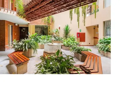 a courtyard with benches and plants in a building at San Borja Pentagonito in Lima