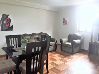 a living room with a table and a couch at Royalty Inn in Lima