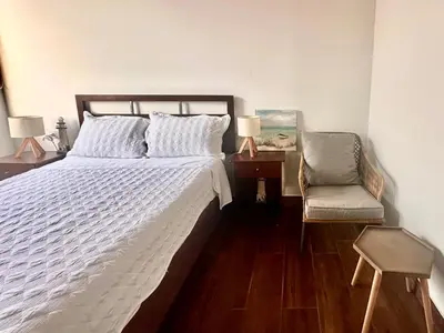 a bedroom with a bed and a chair and a desk at Refugio del Mar Wakama in San Vicente de Cañete