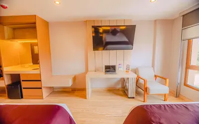 a room with a table and a chair and a tv at Hotel Andesmar Huancayo in Huancayo