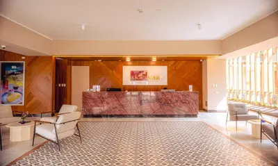 a lobby with a counter and chairs and a reception desk at Hotel Andesmar Huancayo in Huancayo