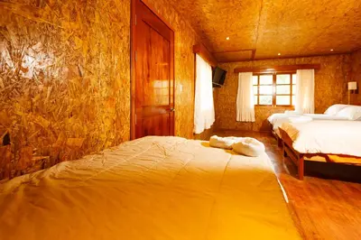a bedroom with two beds and a television in it at Cabañitas San José in Oxapampa