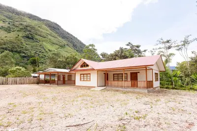 a house with a mountain in the background at Cabañitas San José in Oxapampa