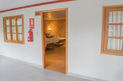 a hallway with a door leading to a living room at Cabañitas San José in Oxapampa