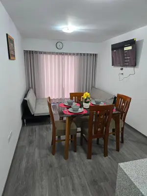 a dining room with a table and chairs and a couch at SAM Apartment Cusco in Cusco