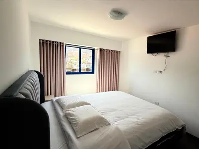 a bedroom with a bed and a television on the wall at SAM Apartment Cusco in Cusco