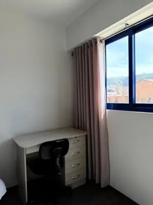 a desk in a room with a window and a chair at SAM Apartment Cusco in Cusco