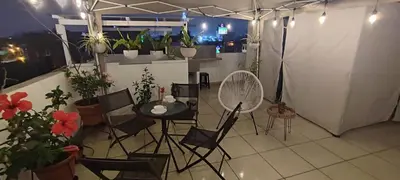a room with a table and chairs and potted plants at Sumaq Apartment Lima Airport in Lima