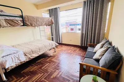 a bedroom with a bunk bed and a couch at Kusi Wasi in Cusco