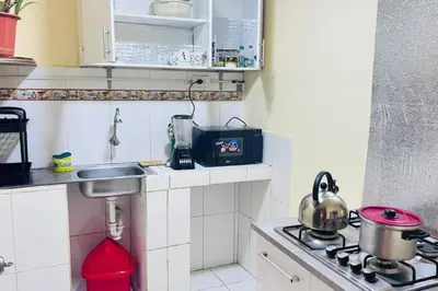 a small kitchen with a sink and a stove at Kusi Wasi in Cusco