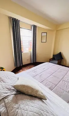a bedroom with a large bed with a pillow on it at Kusi Wasi in Cusco