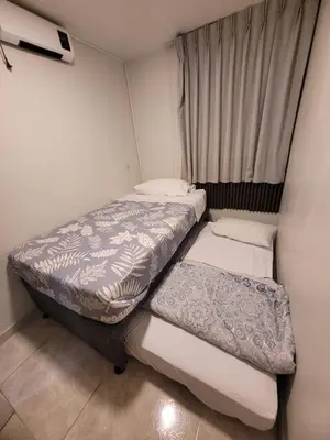 two beds in a small room with a window at Arleth's hosting in Lima