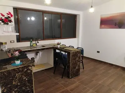 a kitchen with a sink and a counter with chairs at Cori Wasi in Cusco