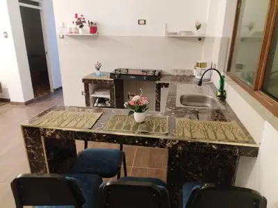 a kitchen with a counter with a sink and chairs at Cori Wasi in Cusco