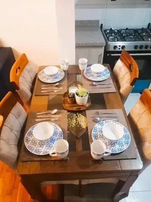 a wooden table with plates and utensils on it at Departamento con Cochera in Lima