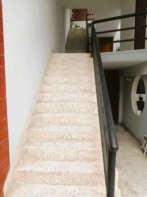 a set of stairs leading up to a building at Departamento con Cochera in Lima