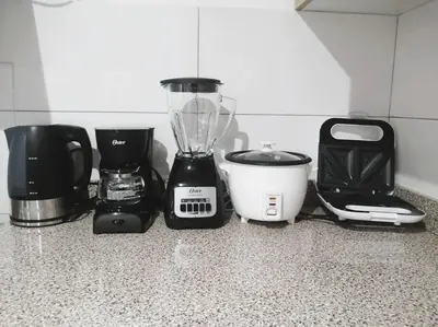 a group of appliances sitting on a kitchen counter at Departamento con Cochera in Lima
