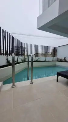 a swimming pool in a building with a fence at Departamento en playa Arica in Lurín