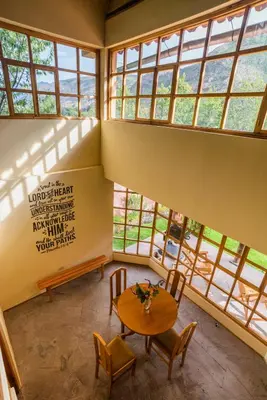a room with a table and chairs and windows at Spacious entire house with awesome mountain views in Urubamba