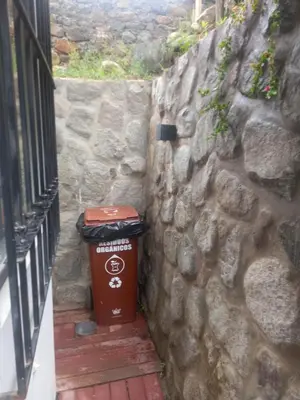 a trash can sitting next to a stone wall at CASA DE CAMPO CON PISCINA EN COCACHACRA HUAROCHIRI SOL TODO EL AÑo in Cocachacra