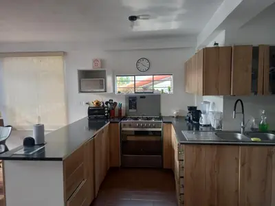 a kitchen with wooden cabinets and a counter top at CASA DE CAMPO CON PISCINA EN COCACHACRA HUAROCHIRI SOL TODO EL AÑo in Cocachacra