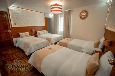 a hotel room with three beds and a chandelier at Intiwatana Apartment in Cusco