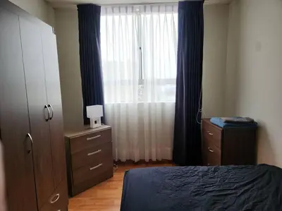 a bedroom with a bed and a dresser and a window at Apartamento 3Hab Seguridad y Cerca del Aeropuerto in Lima
