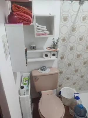 a small bathroom with a pink toilet in it at bungalows in Santa Rosa
