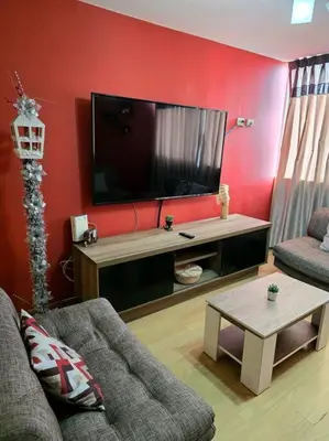 a living room with a tv and a couch and a table at El Refugio de Katte VI in Lima