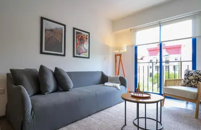 a living room with a blue couch and a table at Qoyllur by Wynwood House in Cusco