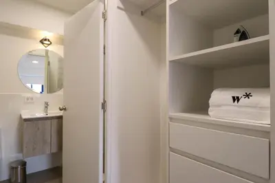 a white bathroom with a sink and a mirror at Qoyllur by Wynwood House in Cusco