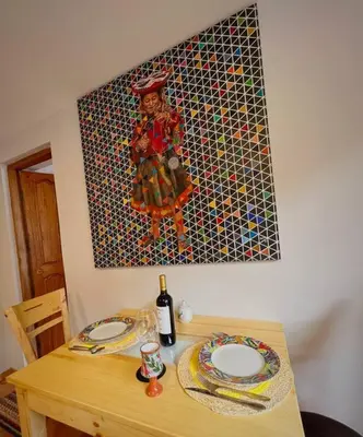 a table with two plates and a painting on the wall at boutique guest house art in the center of cusco in Cusco
