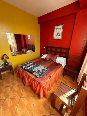 a bedroom with a bed with red and yellow walls at Aquarium in Lima