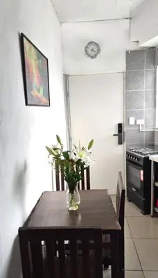 a dining room table with a vase of flowers on it at Departamento en el Centro Historico de Lima Perú in Lima