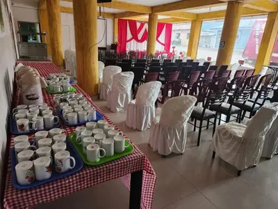 a group of tables with cups and chairs in a room at Yanachaga Hotel - Oxapampa in Oxapampa