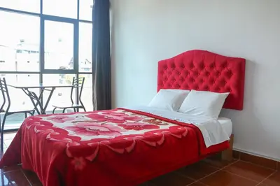 a red bed with a red headboard in a bedroom at Yanachaga Hotel - Oxapampa in Oxapampa