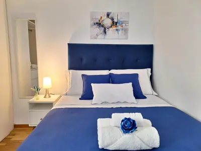 a blue and white bedroom with a bed with towels at Habitación Baño Compartido en Departamento Compartido in Lima