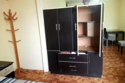 a large black cabinet in a room with a cross at Depawanka 3 Departamento amoblado y equipada in Huancayo