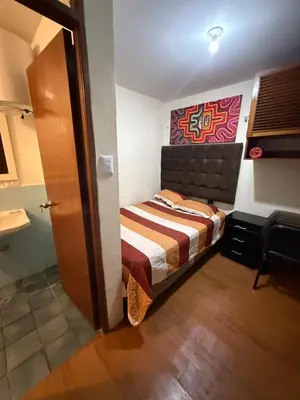 a small bedroom with a bed and a painting on the wall at Residencia Monterrico in Lima