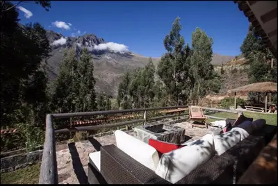 a couch sitting on a balcony with a view of a mountain at SAMAY WASI Rest house in Ollantaytambo