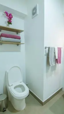 a white bathroom with a toilet and towels at Moderno Loft a Pasos del Centro in Cusco