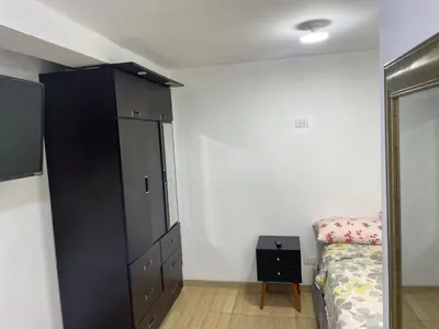 a bedroom with a black cabinet next to a bed at Acogedor departamento en Los Olivos 3 dormitorios in Lima