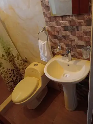 a bathroom with a yellow toilet and a sink at INCA COFFEE Lodge Lucmabamba in Sahuayacu