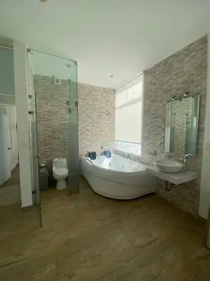a bathroom with a tub and a sink and a toilet at Casa de Playa muy cerca al mar, piscina exclusiva! in Islote Los Leones