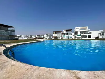 a large blue swimming pool in front of a building at Casa de Playa muy cerca al mar, piscina exclusiva! in Islote Los Leones