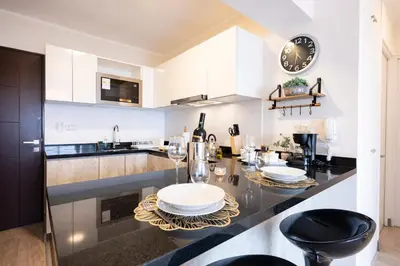 a kitchen with white cabinets and a black counter top at G15 Apartments by Vibrant in Lima